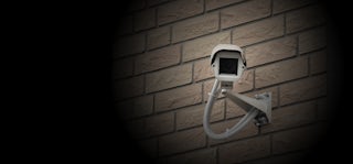 Security camera on brick wall.